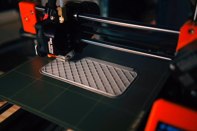 Part being additively built on a printer bed with visible layer infill